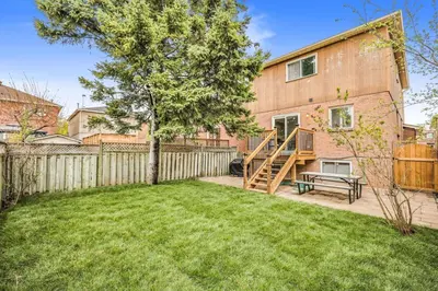 a backyard with a wooden fence and a house at 3BR Pickering Retreat with BBQ and Patio Delight in Pickering