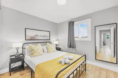 a bedroom with a large bed and a mirror at 3BR Pickering Retreat with BBQ and Patio Delight in Pickering