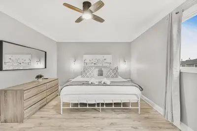 a white bedroom with a bed and a ceiling fan at 3BR Pickering Retreat with BBQ and Patio Delight in Pickering