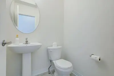 a bathroom with a toilet and a sink and a mirror at Stylish 3BDR in Pickering Heart Free Parking in Pickering