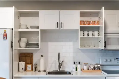 a kitchen with white cabinets and a sink at Waterfront Bliss Firepit and BBQ in Hanover
