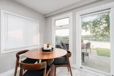 a dining room with a table and chairs and windows at Waterfront Bliss Firepit and BBQ in Hanover