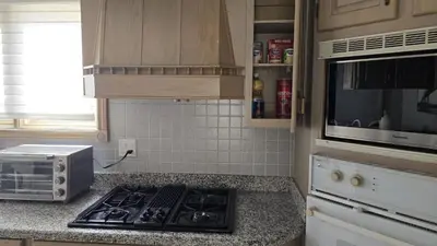 a kitchen with a stove and a microwave at Spacious, Peaceful & Perfectly Located - 4BR,3BA in London