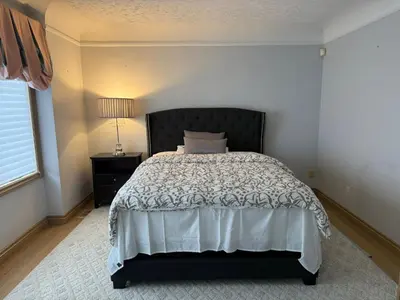 a bedroom with a bed and a lamp and a window at Spacious, Peaceful & Perfectly Located - 4BR,3BA in London