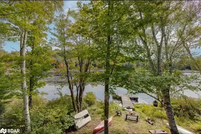 an aerial view of a lake with a picnic table and trees at The Beaver Den in Haliburton