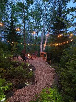 a patio with chairs and a table with lights at The Beaver Den in Haliburton
