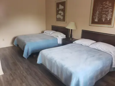 a hotel room with two beds and a lamp at Georgian Inn Motel in Wasaga Beach