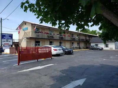 a parking lot with cars parked in front of a building at Georgian Inn Motel in Wasaga Beach
