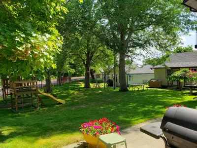 a park with a playground with a slide and flowers at Georgian Inn Motel in Wasaga Beach