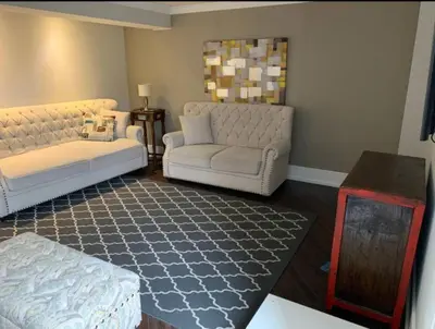 a living room with two white couches and a table at Basement apartment in Vaughan