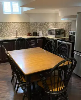 a kitchen with a wooden table and chairs at Basement apartment in Vaughan