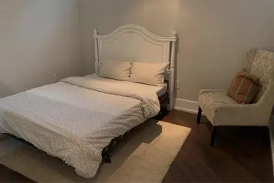 a small bedroom with a bed and a chair at Basement apartment in Vaughan