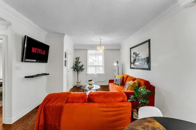 a living room with an orange couch and a table at 80's Retro Toronto Time Capsule - 2 Bedrooms in Toronto