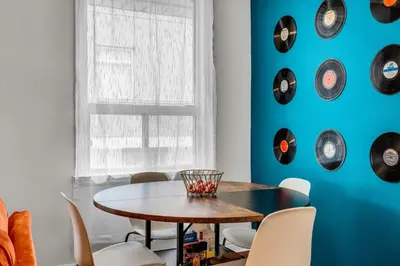a dining room with a table and clocks on the wall at 80's Retro Toronto Time Capsule - 2 Bedrooms in Toronto