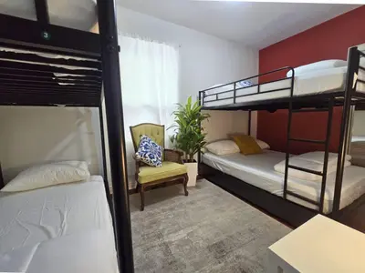 a room with two bunk beds and a chair at 80's Retro Toronto Time Capsule - 2 Bedrooms in Toronto