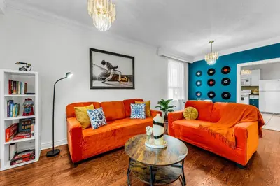 a living room with two orange couches and a table at 80's Retro Toronto Time Capsule - 2 Bedrooms in Toronto