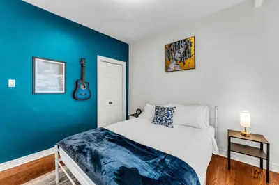a bedroom with a white bed and a blue wall at 80's Retro Toronto Time Capsule - 2 Bedrooms in Toronto