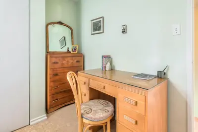 a room with a wooden dresser and a mirror at Cozy 2BR Home with Workspaces, Fireplace and Parking in Toronto