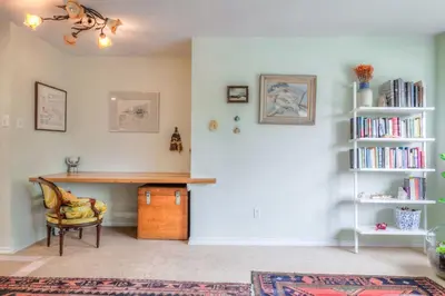 a room with a desk and a book shelf with books at Cozy 2BR Home with Workspaces, Fireplace and Parking in Toronto