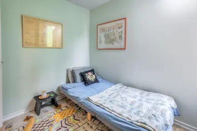 a small bedroom with a bed and a table at Cozy 2BR Home with Workspaces, Fireplace and Parking in Toronto
