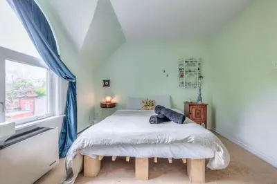 a bedroom with a bed and a window at Cozy 2BR Home with Workspaces, Fireplace and Parking in Toronto