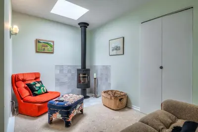 a living room with a red chair and a stove at Cozy 2BR Home with Workspaces, Fireplace and Parking in Toronto