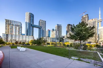 a park with white furniture and a city skyline at Downtown Urban Oasis I Entertainment District in Toronto