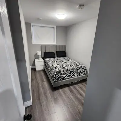a bedroom with a bed and a nightstand with a bed sidx sidx sidx sidx at Gracy's property in Thamesford