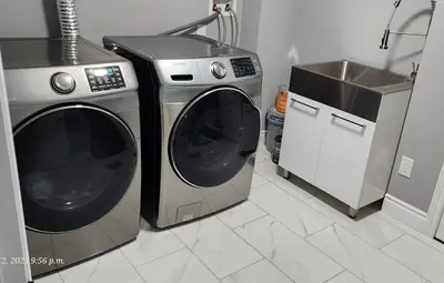 a kitchen with a washing machine and a sink at Gracy's property in Thamesford