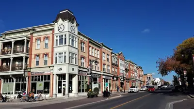 a clock tower on a building on a city street at 5mins Shopping, Stylish Modern 2BR Kitchen Suite in Markham in Markham