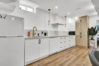 a white kitchen with white cabinets and a sink at 5mins Shopping, Stylish Modern 2BR Kitchen Suite in Markham in Markham