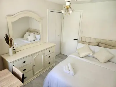 a bedroom with two beds and a mirror at 3Q Ltd in Hamilton