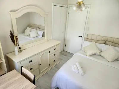 a bedroom with two beds and a mirror at 3Q Ltd in Hamilton