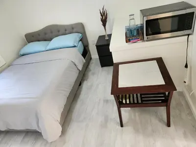 a bedroom with a bed and a table with a tv at 3Q Ltd in Hamilton