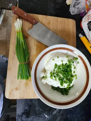 a plate of food with onions and green onions on a cutting board at 3Q Ltd in Hamilton