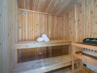 a wooden sauna with two towels sitting on a shelf at Sleep 8 Hot Tub Backyard Retreat 5 Min To Falls in Niagara Falls