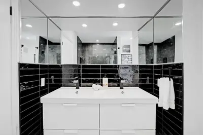 a bathroom with a white sink and a mirror at Sleep 8 Hot Tub Backyard Retreat 5 Min To Falls in Niagara Falls