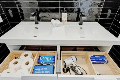 a bathroom vanity with a sink and toilet paper at Sleep 8 Hot Tub Backyard Retreat 5 Min To Falls in Niagara Falls