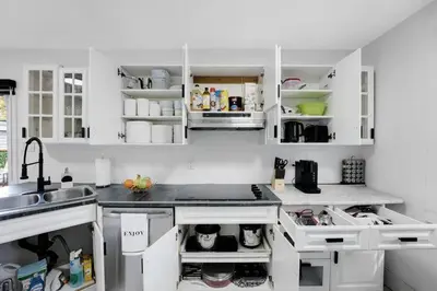 a kitchen with white cabinets and a sink at Sleep 8 Hot Tub Backyard Retreat 5 Min To Falls in Niagara Falls