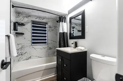 a bathroom with a sink and a tub and a toilet at Outdoor Sauna Hot Tub Playroom Port Dallhousie in St. Catharines