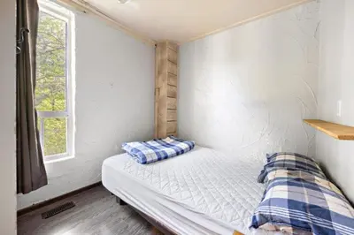 a bedroom with a bed in a room with a window at Margaritaville - Big Space with Lots of fun and Hot Tub 38R in Blue Mountains