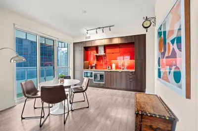 a dining room with a table and chairs and a kitchen at Luxury 2 Bedroom CN Tower View in Toronto