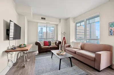a living room with a couch and a tv at Luxury 2 Bedroom CN Tower View in Toronto