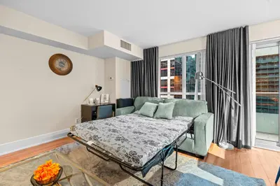 a living room with a couch and a window at Classy 1-Bedroom & Den Condo in Heart of Downtown in Toronto