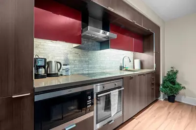 a kitchen with red cabinets and a sink at Classy 1-Bedroom & Den Condo in Heart of Downtown in Toronto