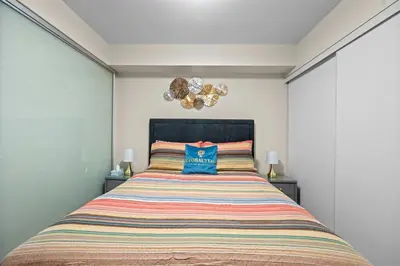 a bedroom with a bed with a blue pillow on it at Classy 1-Bedroom & Den Condo in Heart of Downtown in Toronto
