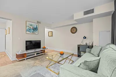 a living room with a couch and a tv at Classy 1-Bedroom & Den Condo in Heart of Downtown in Toronto