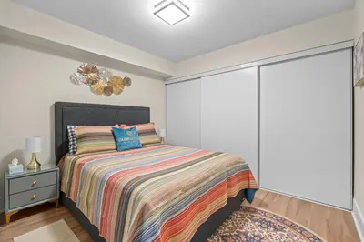 a white bedroom with a bed and a window at Classy 1-Bedroom & Den Condo in Heart of Downtown in Toronto