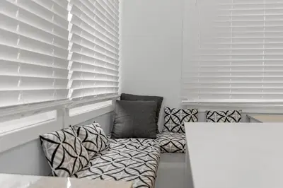 a living room with white blinds and a couch at Crystal Tides Retreat in Fort Erie
