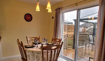 a dining room with a table and a large window at HB Guest Home in Waterloo